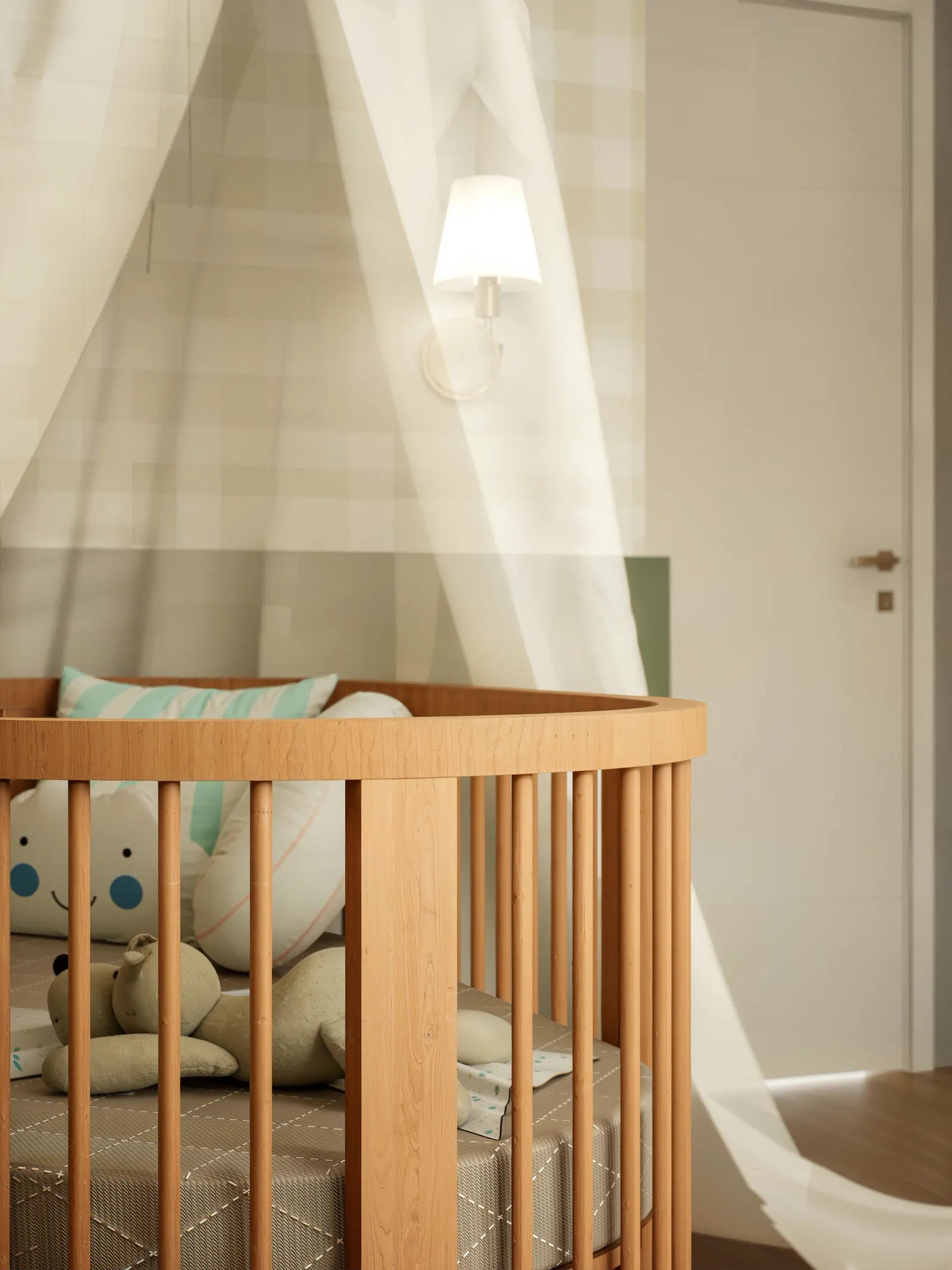 A wooden crib beneath a soft canopy in a calm nursery